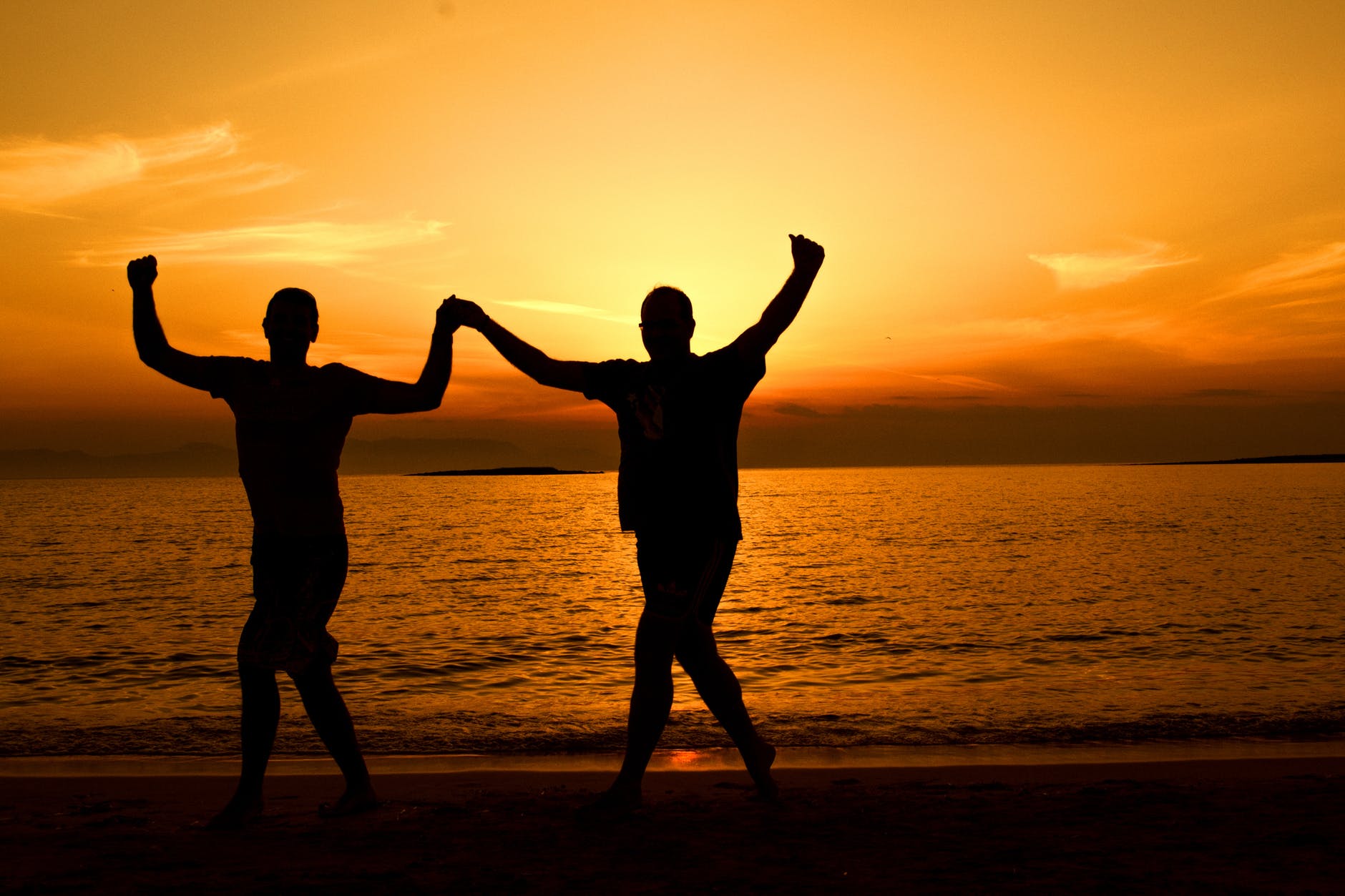 silhouette people on beach at sunset